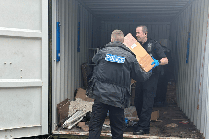 Police Officers assisting Trading Standards to seize the suspected illegal items