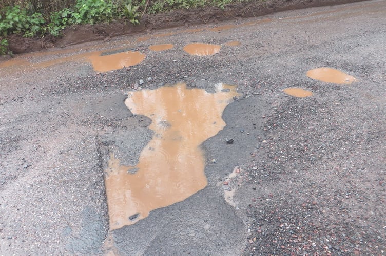 Potholes the width of the road at Moorlake, impossible to avoid and deep. SR 3455