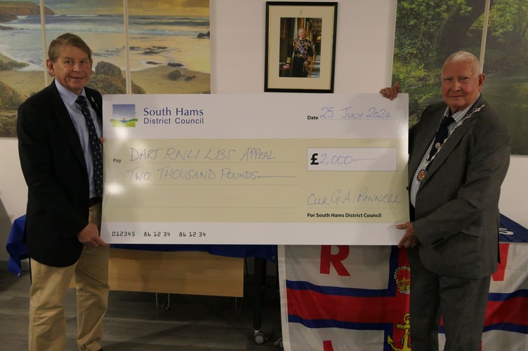 Commordore Jake Moores OBE DL Royal Navy, chair of the Dart RNLI Appeal, receiving a cheque for £2,000 from South Hams District Council's vice chair, Cllr Guy Pannell
