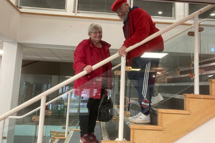 Anne Rainbow helps her husband Stephen Thomas down the stairs