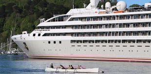 Rowers pass by 'Le Lyrial' cruise ship in the Dart 