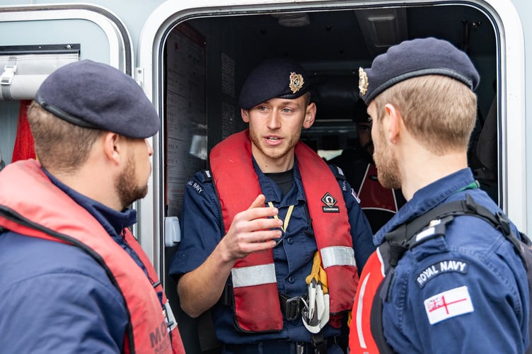 Three Officer Cadets confer during the assessment - The Royal Navy
