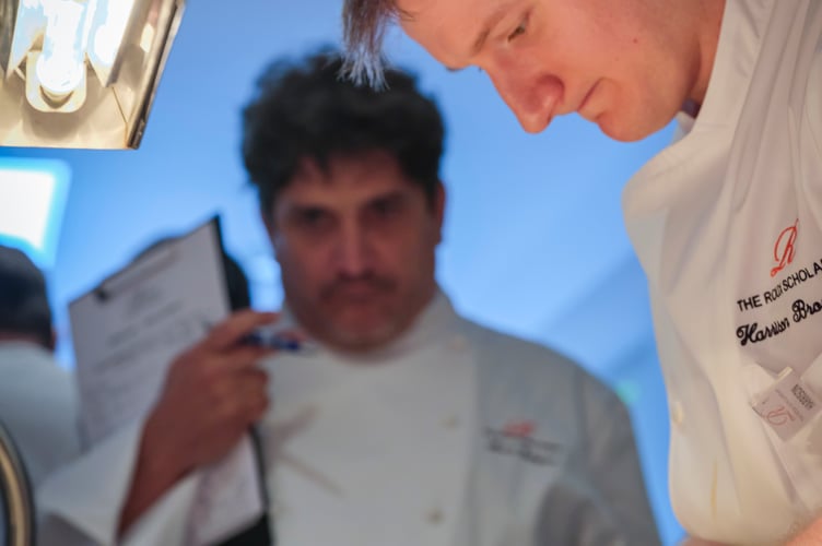 Roux Scholarship judge watching Harrison Brockington prepare his competition dish.