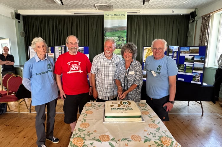 The celebration cake is cut by Sue Viccars, author of the Two Moors Way Guide and Two Moors Way Association Information Officer, with left, Janet Auckland, Colin Piper, Les Bright and right, John Howell, Association members. AQ 2100